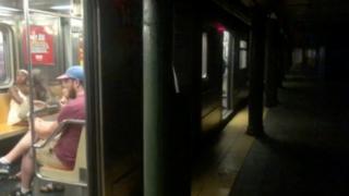 Train at darkened platform at 66th Street subway station in Manhattan, NY, 13 July 2019