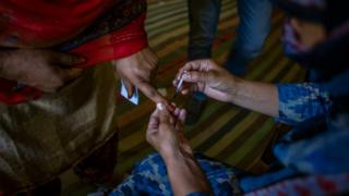 polling officer ink marks the finger of a kashmiri woman before casting her vote on the third phase of Indian general-election on April 23, 2019, in Anantnag, south of Srinagar, the summer capital of Indian administered Kashmir, India.