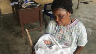 Kafayat's sister, Iya Shaki, holding the newborn at Mama Stella