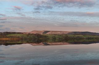 Hills reflected in water
