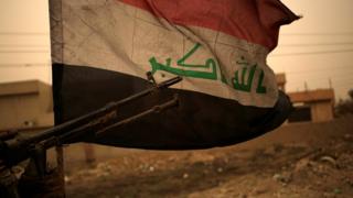 Iraqi flag seen during a sand storm in Bartella, east of Mosul, Iraq (1 November 2016)