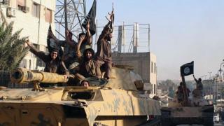 fighters from the Islamic State group ride tanks during a parade in Raqqa, Syria on 30 June, 2014
