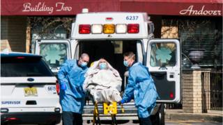 Paramedics load a patient into an ambulance