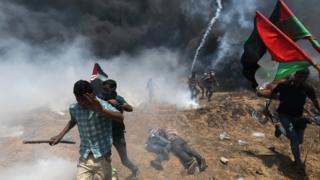 Palestinian demonstrators run for cover during a protest against U.S. embassy move to Jerusalem