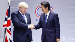 Премьер-министр Великобритании Борис Джонсон и премьер-министр Японии Синдзо Абэ обмениваются рукопожатием во время двусторонней встречи на полях саммита G7.