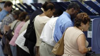 Una fila de personas votan en las elecciones.