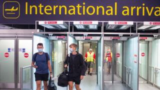 Masked passengers arriving at Gatwick airport