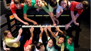 Children-gathered-around-piano.
