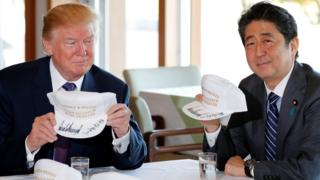 特朗普(前左)与安倍晋三(前右)展示各自的纪念鸭舌帽(5/11/2017)