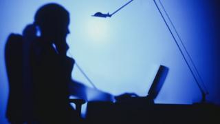 silhouette of woman at computer