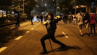 Демонстрант бросает камни в ОМОН во время акции протеста против нового президента Бразилии Мишеля Темера после того, как Сенат сместил бывшего президента Дилму Руссефф в Сан-Паулу, (02 сентября 2016 г.)