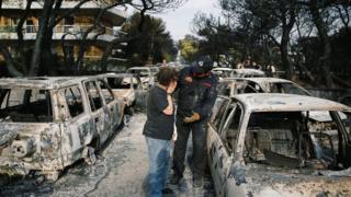 Реакција жене која покушава да пронађе свог пса међу запаљеним аутомобилима
