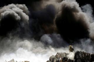 A firefighter works to extinguish the fire at a recycling centre in Ciudad Juarez, Mexico