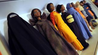 Barbies wearing cultural clothes from around the world, including a Burkha (L), are displayed during a touring exhibition at a book store in downtown Milan on November 29, 2010. The 500 Barbies outfitted by Italian designer Eliana Lorena were part of a charity auction at Sotheby's in London in 2009, in celebration of Barbie�s 50th anniversary. Today each Barbie of this collection cost 180 euros (236 USD).
