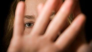 Woman holding up hand over face