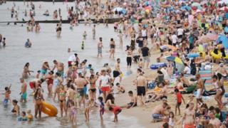 Swimmers and sunbathers on Bournemouth beach in Dorset