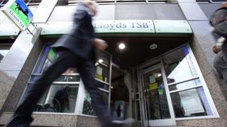 A man walks in front of Lloyds TSB bank