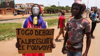 Protesters wey carry placard