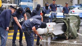 الشرطة الإيطالية إلى جانب الصاروخ المضبوط