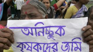 সিঙ্গুরের কৃষাণীর হাতে জমি ফেরত দেয়ার দাবি নিয়ে প্ল্যাকার্ড।