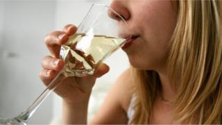 A woman drinking white wine