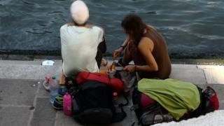Tourists make coffee on side of river