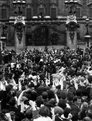 Crowds outside Buckingham Palace cheer on VE Day