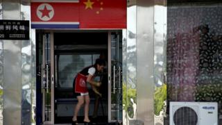 Una empleada norcoreana limpia el suelo en un restaurante en Dandong, China
