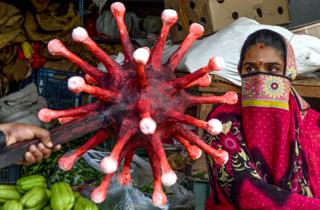 A policeman gestures towards a woman with coronavirus-themed mace