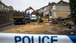 Workers remove debris at the crash site on Lansdown Lane in Bath