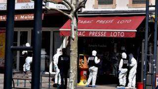 French Police officers wearing protective suits stand in a street in the centre of Romans-sur-Isere, on 4 April 2020