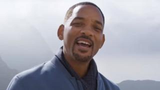 Will Smith standing by some mountains