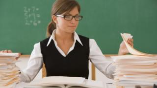 Teacher with pile of marking