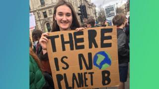 A girl holding a sign saying 'There is no planet B'