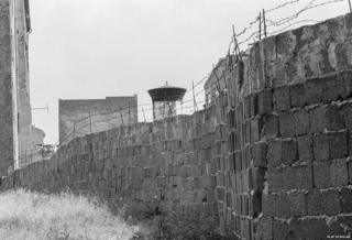 A stretch of the Berlin Wall, 1962. The wall was topped with barbed wire to prevent East Berliners from escaping