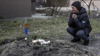 Tanya Nedashkivska grieves next to the grave of her husband buried in the backyard of her house in Bucha, Ukraine, April 4th, 2022.
