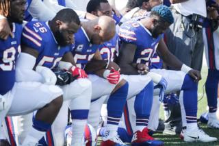 米アメフト試合前の国歌演奏で膝をつき黒人への暴力に抗議するデンバー・ブロンコスの選手たち(24日、ニューヨーク)