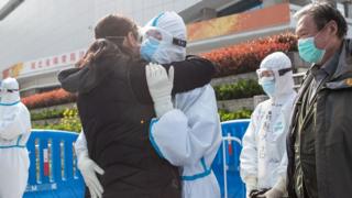 A woman (L) who recovered from COVID-19 hugs a medical staff member before leaving a temporary hospital set up to treat people with the COVID-19 coronavirus in Wuhan, China, on 10 March, 2020.