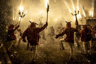 The crowd of spectators dance under sparks.