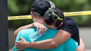 При поддержке друга мужчина плачет о жертвах массовой стрельбы в квартале от Орландо, штат Флорида, 12 июня 2016 года.