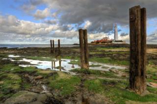 Water-logged fields with a lighthouse in the background