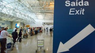 Tourists line up 11 March, 2004 to have their passports checked by federal police officers at Rio de Janeiro international airport's departure gate in Rio de Janeiro, Brazil.