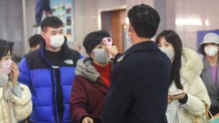 Passengers in Hangzhou, China are screened with temperature checks after arriving from Wuhan