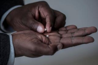 A man holds rough diamonds found by former illegal, now independent, miners, on June 5, 2018 in Kimberly, Northern Cape, South Africa. Unlike formal mining operations, small-scale miners pan for precious minerals around the edge of established quarries in the hope of coming up lucky. In April, some 800 illicit miners received licences to operate on a vast tract of land near Kimberley in the country"s centre. The landmark deal was aimed at curbing the rapid growth of illegal mining which has been spurred on by rising unemployment.