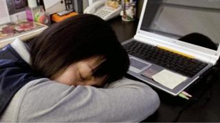 A sleeping girl is sitting on the desk