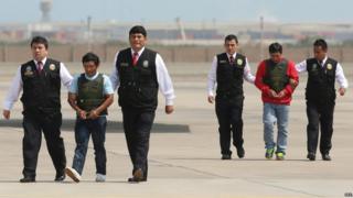 Alexander Alarcon Soto, known as "Comrade Renan" (2-R), and Dionisio Ramos, known as "Comrade Yuri" (2-L), are presented to the media at the international airport in Lima, Peru, 10 August 2015