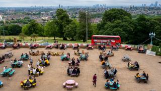 Visitors drink at The Terrace beer garden at Alexandra Palace, London - 4 July 2020