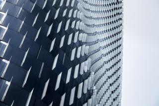 A curved building exterior wall with glass and metal panels