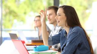 Woman holding her hand up in class