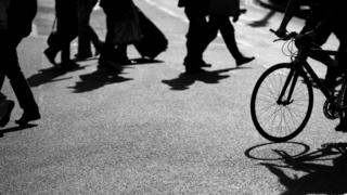 Люди, идущие и езда на велосипеде на работу